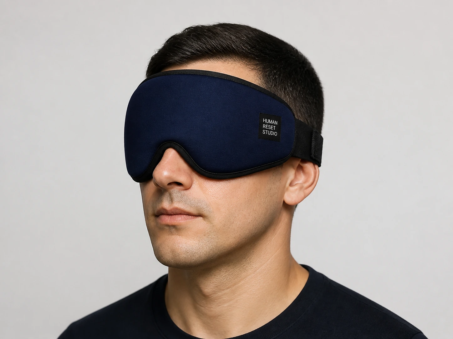 Close-up of a man wearing the navy HRS eye wrap, showing its fit and textile detail